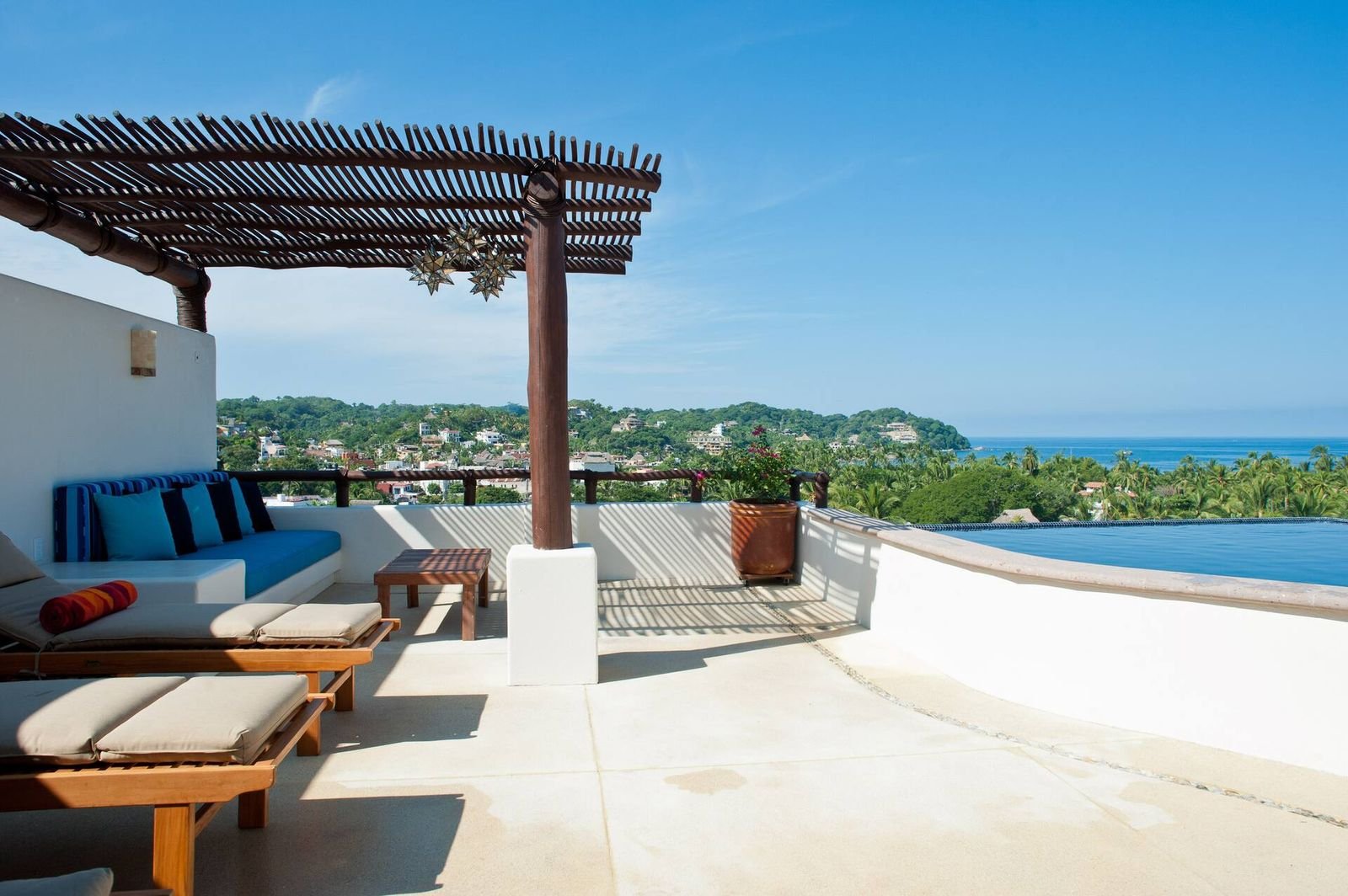 Rooftop pergola lounge and infinity pool looking over Sayulita to the Pacific